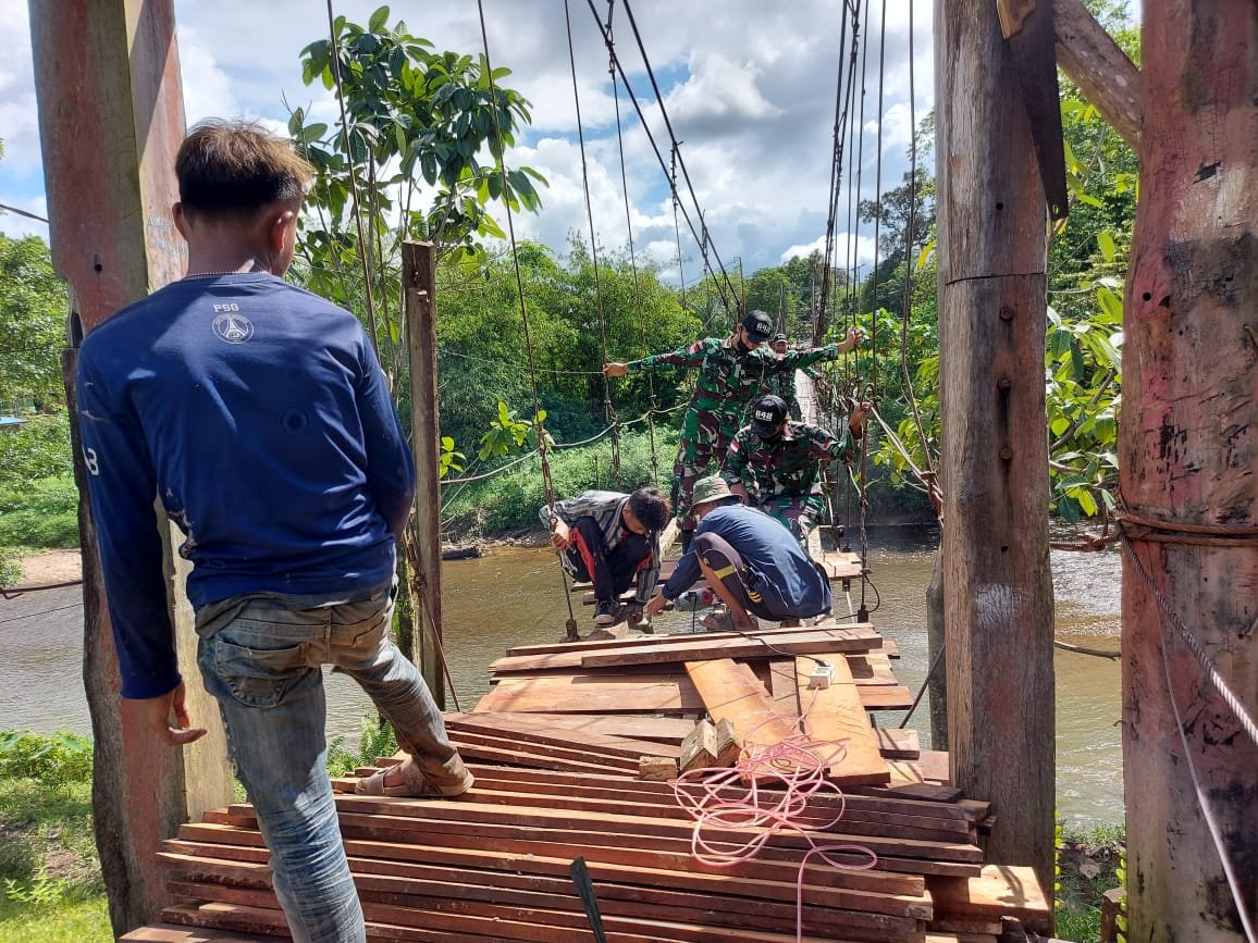 Satgas Pamtas Yonif 642/Kapuas dan Masyarakat Perbaiki Jembatan Rusak