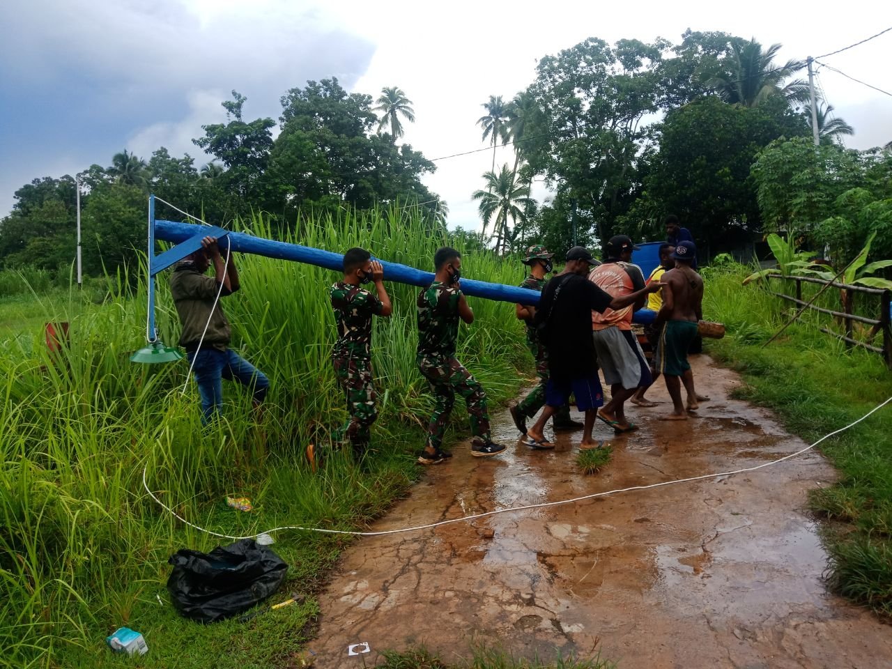 Satgas Pamtas Yonif 125/SMB Bantu Warga Toray Pasang Tiang Listrik