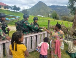 Satgas Yonif Mekanis 203/AK Bagikan Baju dan Alat Tulis Door to Door