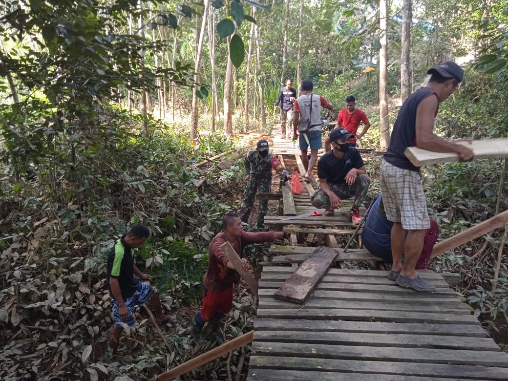 Prajurit Yonif 642 Bersama Warga Perbaiki Jembatan Rusak Akibat Banjir