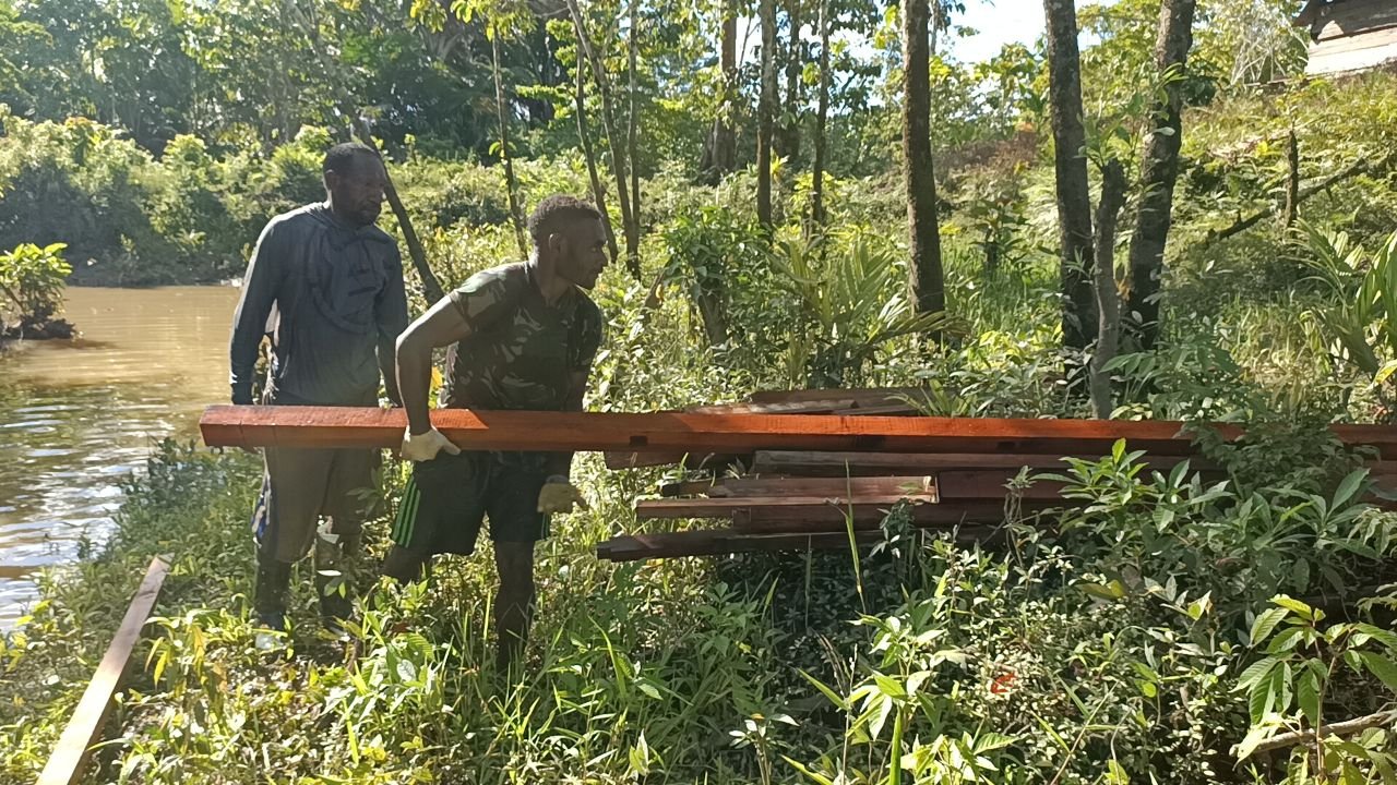 Personel TMMD Kodim 1711 Bantu Warga Angkut Kayu untuk Bangun Rumah