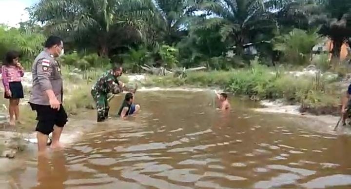 Babinsa dan Bhabinkamtibmas Desa Santaban Bantu Warga Saat Panen Ikan