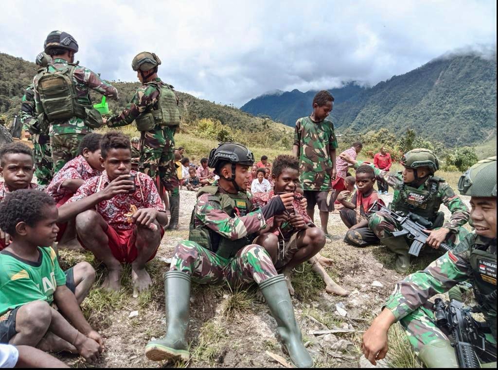 Satgas Yonif Raider 321 Kostrad Bagikan Bubur Hijau untuk Warga