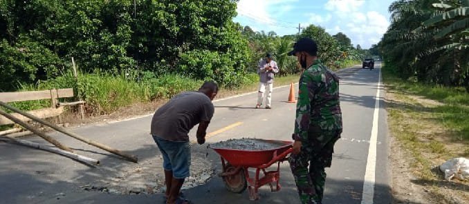 Antisipasi Kecelakaan, Satgas Yonif 642 Perbaiki Jalan Berlubang Bareng Warga