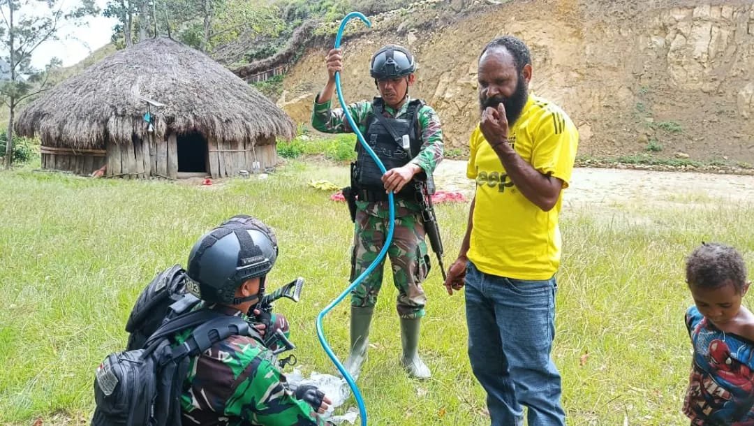 Personel Satgas Yonif Mekanis 203/AK Hadiri Warga yang Kesulitan