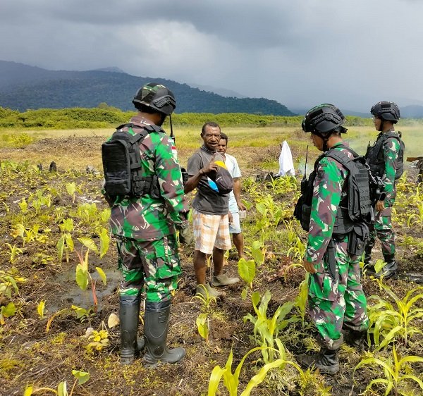 Satgas Yonif Raider 142/KJ Bantu Warga Bersihkan Kebun