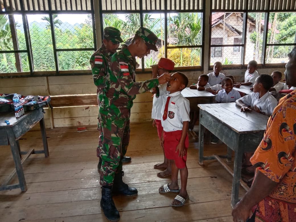 Yonif 126/KC Sosialisasi Kesehatan dan Distribusi Vitamin Obat Cacing untuk Anak Sekolah di Perbatasan RI-PNG