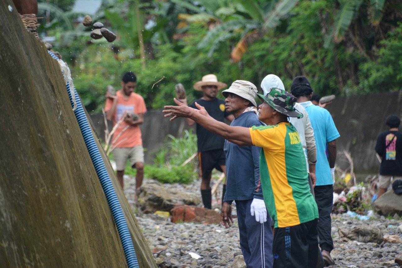 Satgas Yonarmed 1 Kostrad dan Warga Pasang Bronjong di Sungai Waiheru Cegah Banjir Longsor